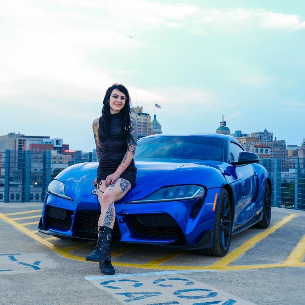 Faye next to her 2023 Manual Transmission Stratosphere Blue Supra - Thrill NG